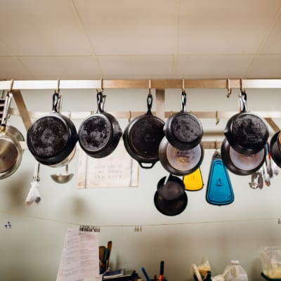 https://www.pexels.com/photo/assorted-frying-pans-hanging-on-pot-rack-2868977/