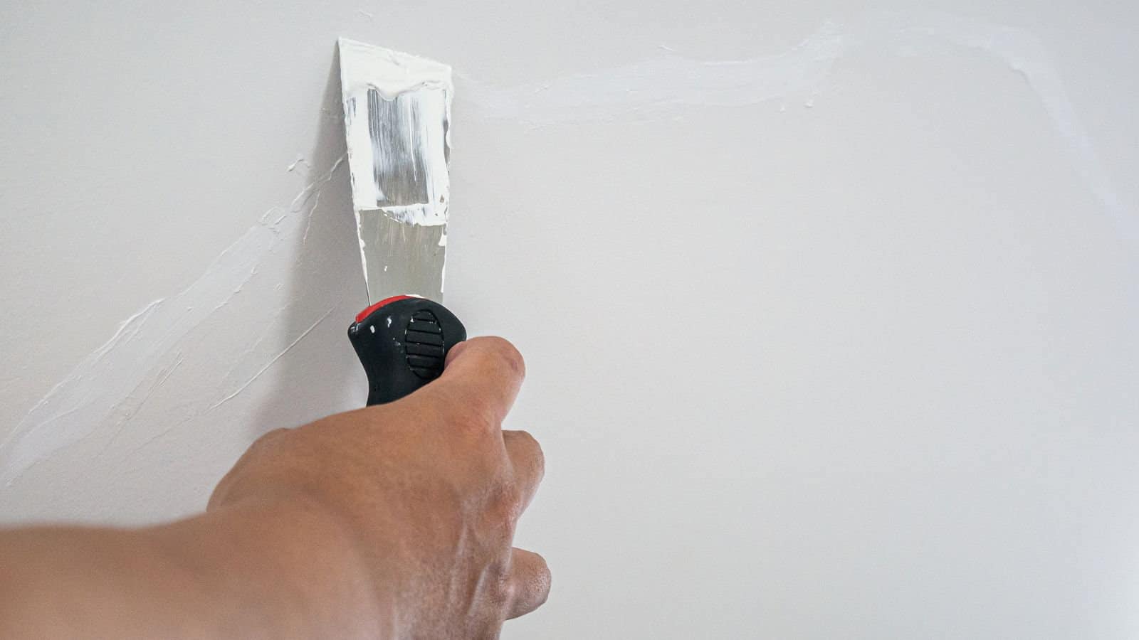 Plasterer hand repair crack white wall