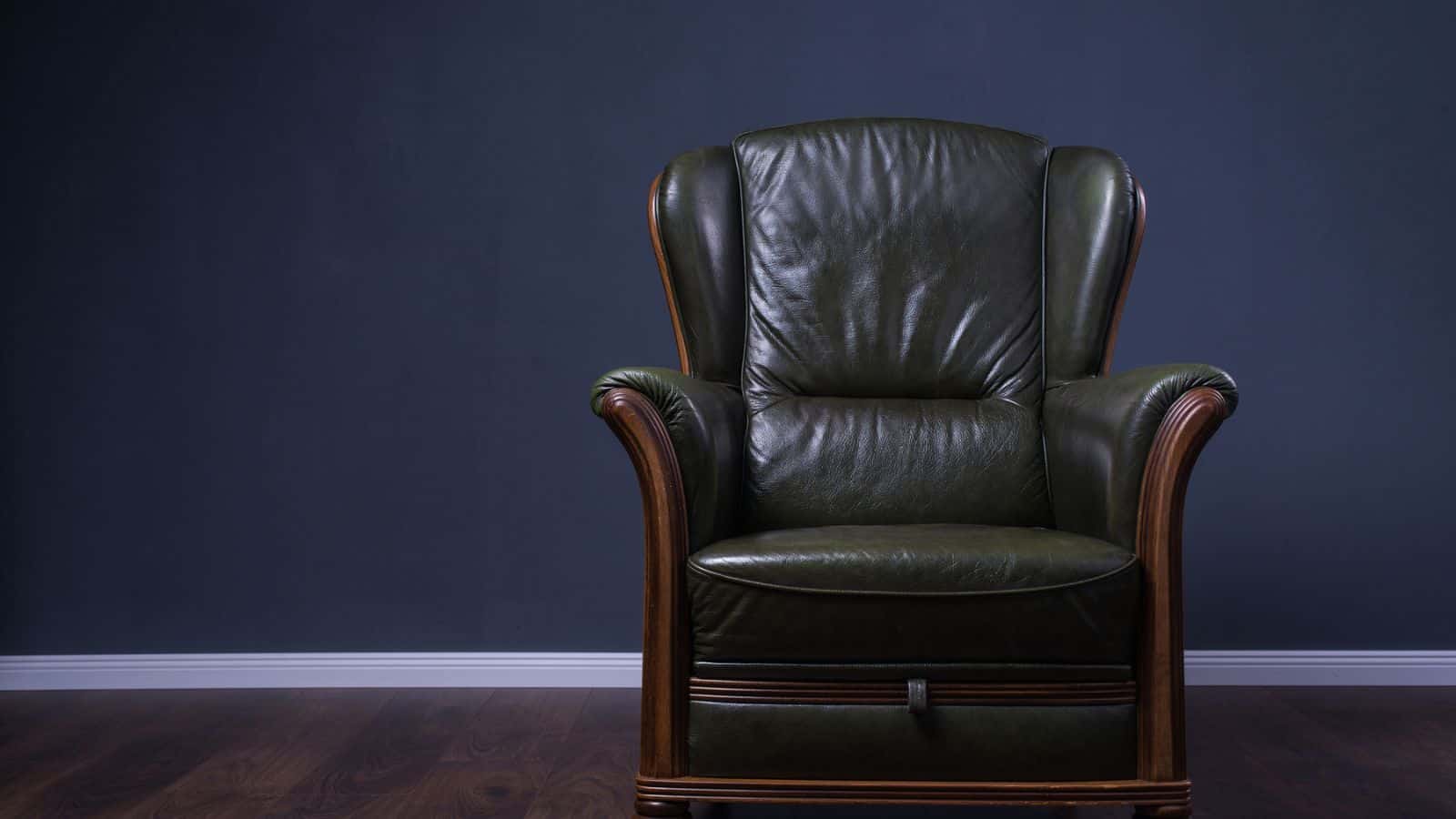Green leather armchair in front of the wall