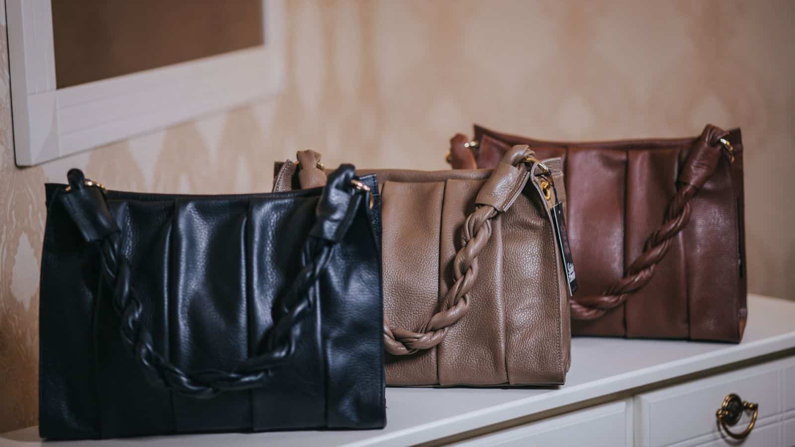 white, beige and brown leather handbags put on the white dresser