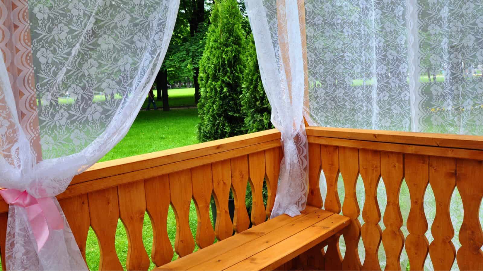 wooden porch with lace curtains
