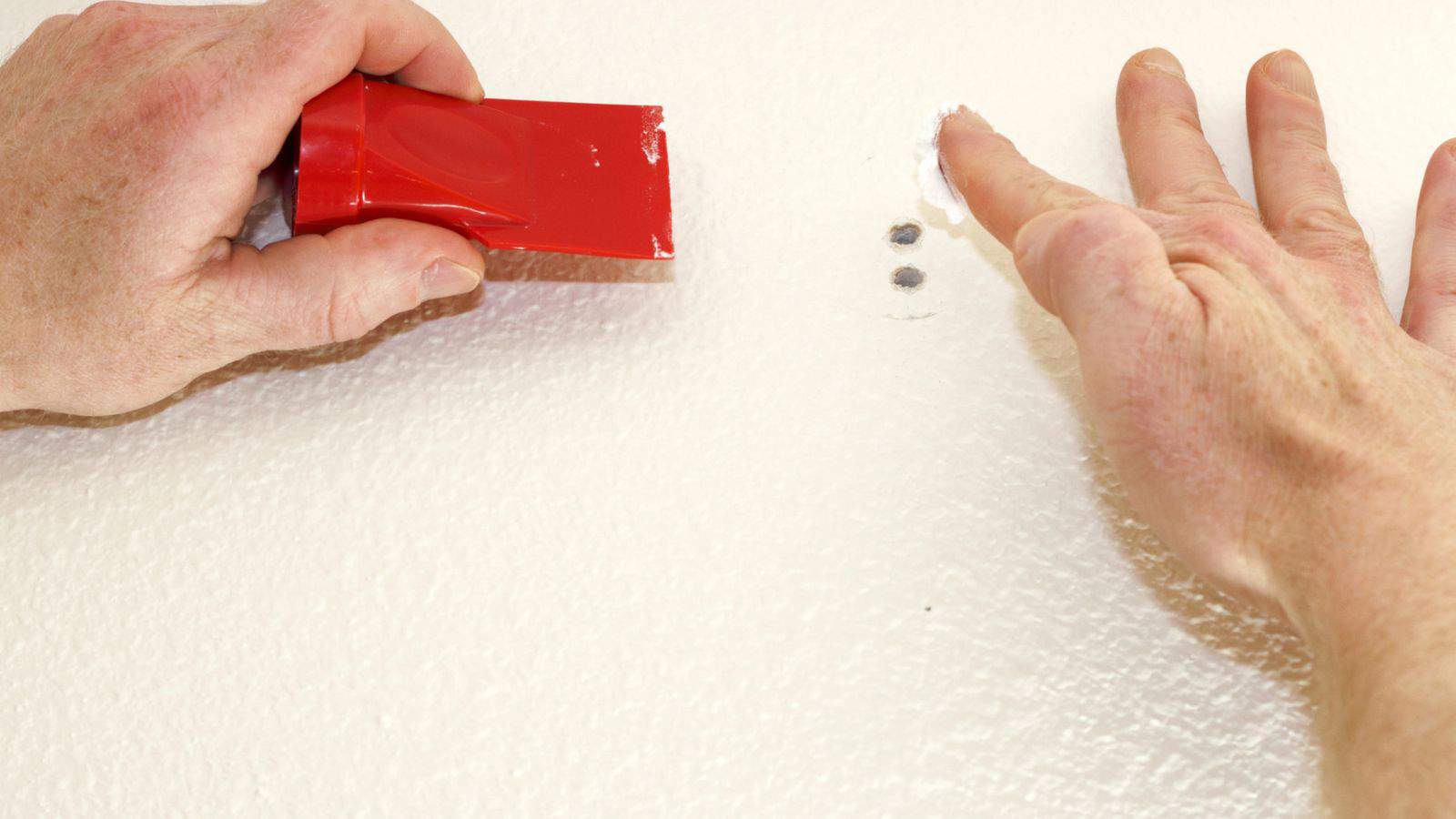 applying spackling on a hole to a drywall