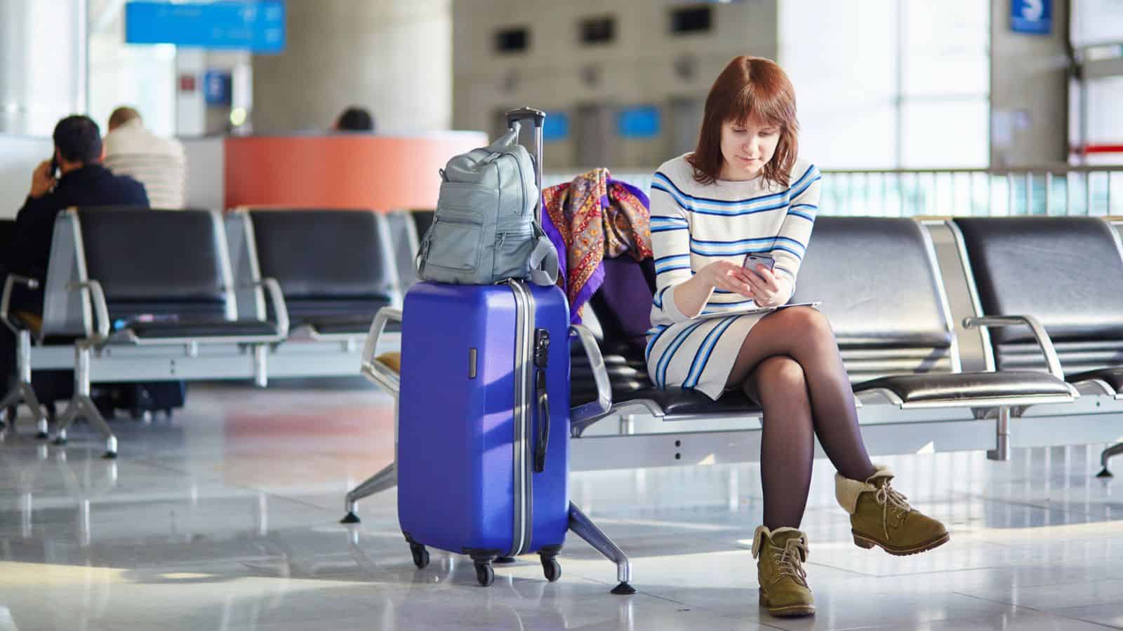 woman at airport waiting with luggage