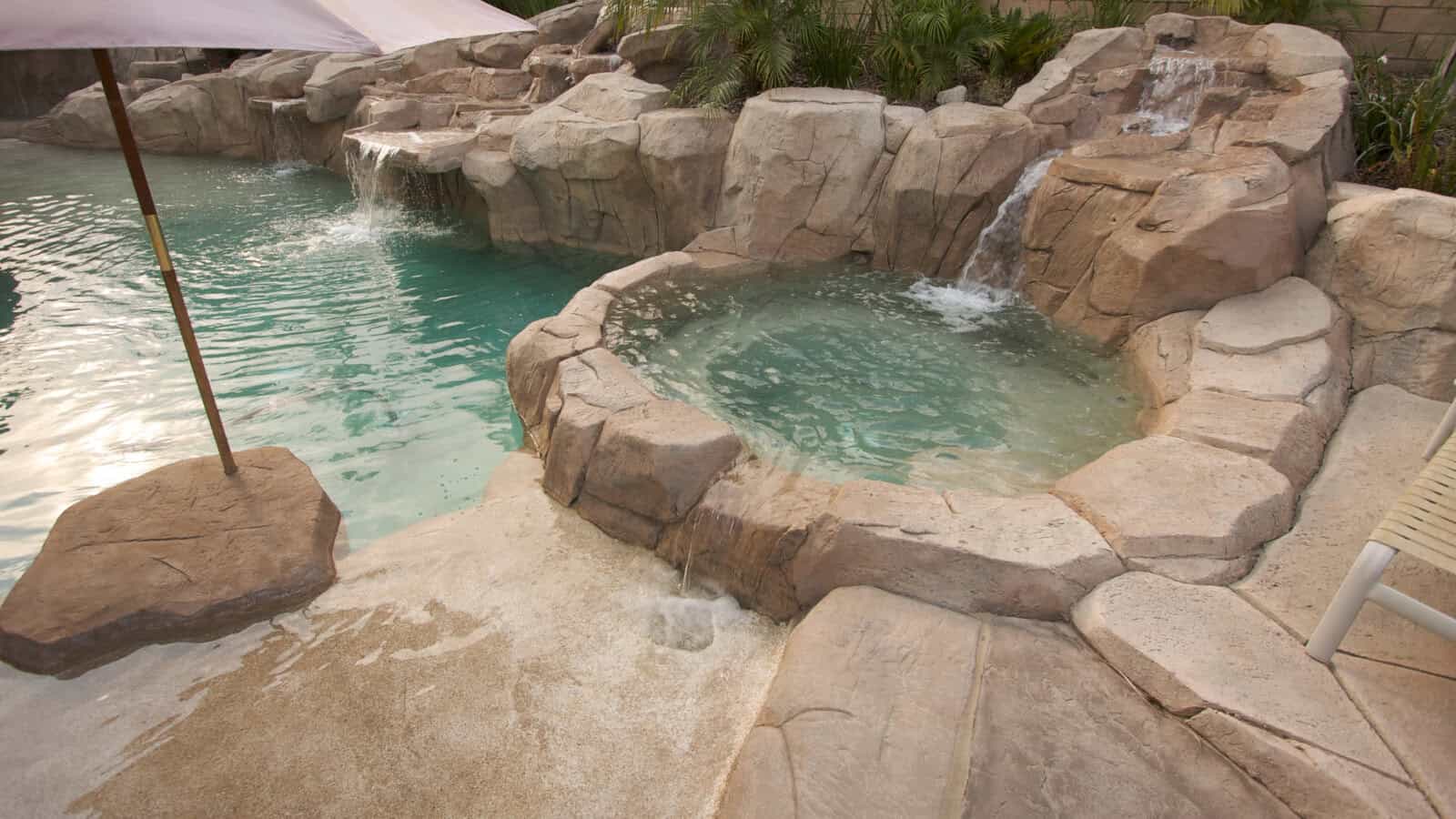 resort style pool with rocks and waterfall